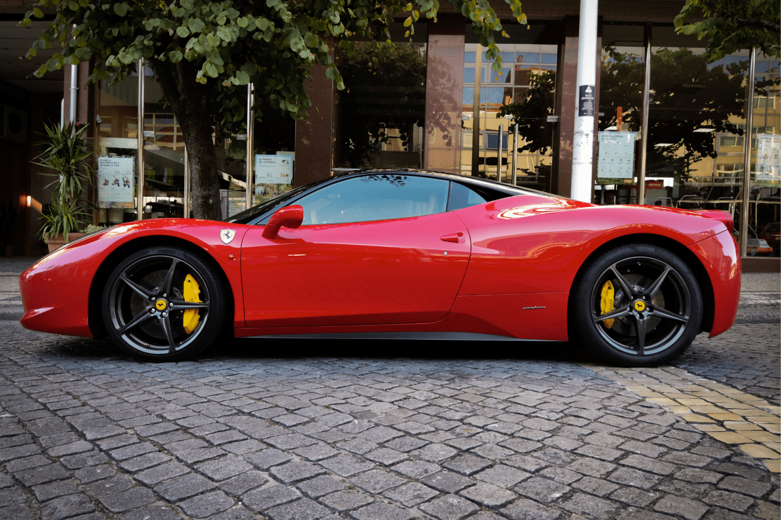 a red sports car parked on a brick road