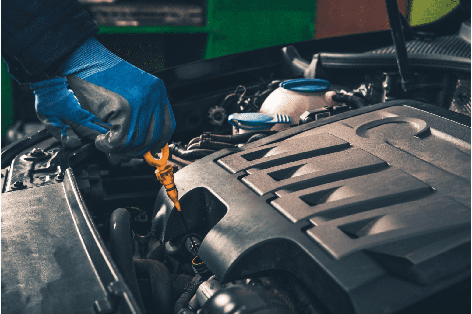 a person using a yellow tool to check the engine of a car